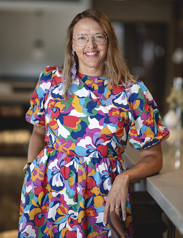 2025-04-footer-photo Jolinda Anderson, web designer and owner of Shapes & Colors by Jolinda, standing at a counter inside her downtown Richmond, Virginia workspace